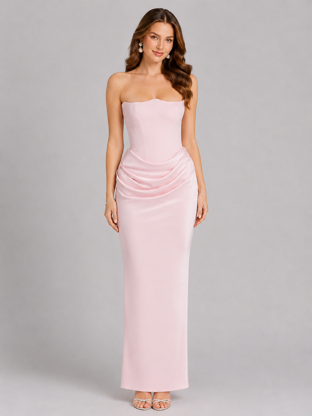 Woman wearing a strapless pink gown against a gray background