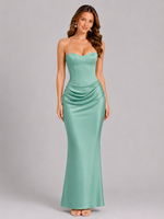 Woman wearing a strapless green gown on a gray background