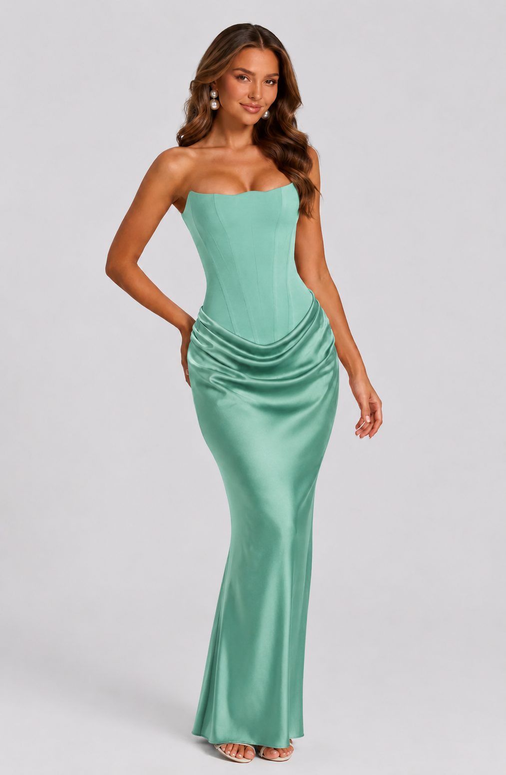 Woman wearing a strapless green gown on a gray background