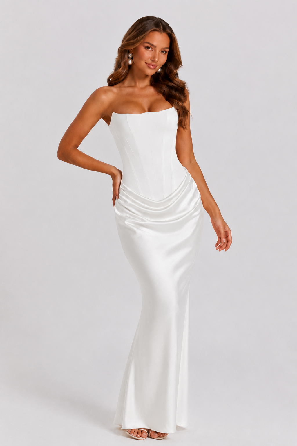 Woman wearing a strapless white evening gown on a plain background