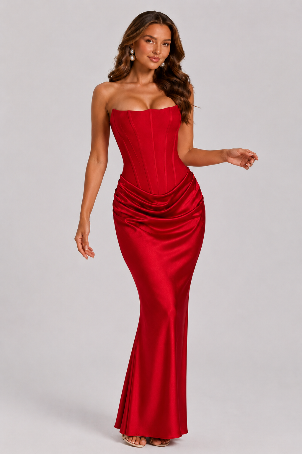 Woman wearing a strapless red evening gown on a gray background