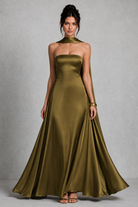 Woman wearing a green strapless gown against a gray background