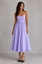 Woman wearing a light purple dress against a gray background