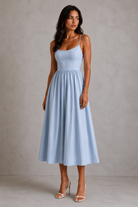 Woman wearing a light blue dress against a plain background