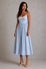 Woman wearing a light blue dress against a plain background