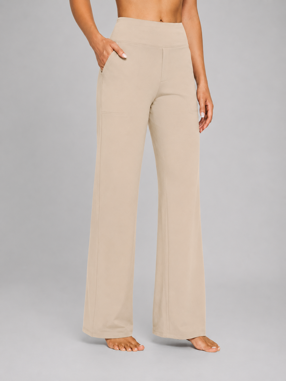Beige high-waisted pants worn by a person on a gray background