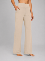 Beige high-waisted pants worn by a person on a gray background