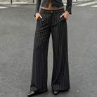 Person wearing black pinstripe pants on a gray street