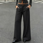Person wearing black pinstripe pants on a gray street