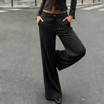 Person wearing black pinstripe pants and a matching top on a street.