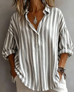 Person wearing a gray and white striped shirt against a neutral background