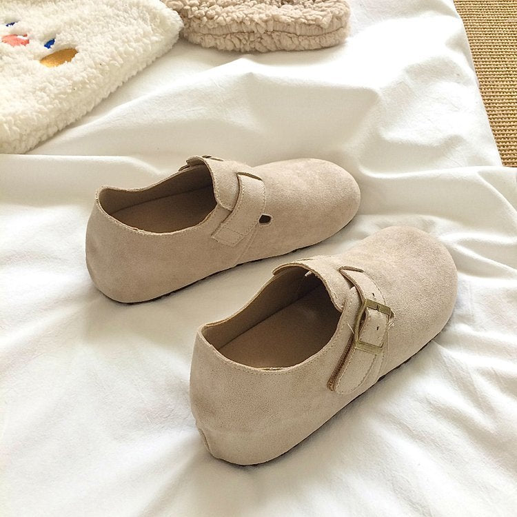Pair of beige loafers on a light-colored surface