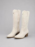 Pair of white knee-high boots on a gray background