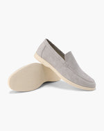 Gray loafers with beige soles on a white background