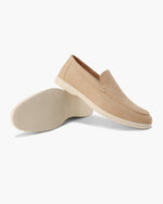 Pair of beige loafers on a white background