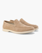Pair of tan loafers on a white background