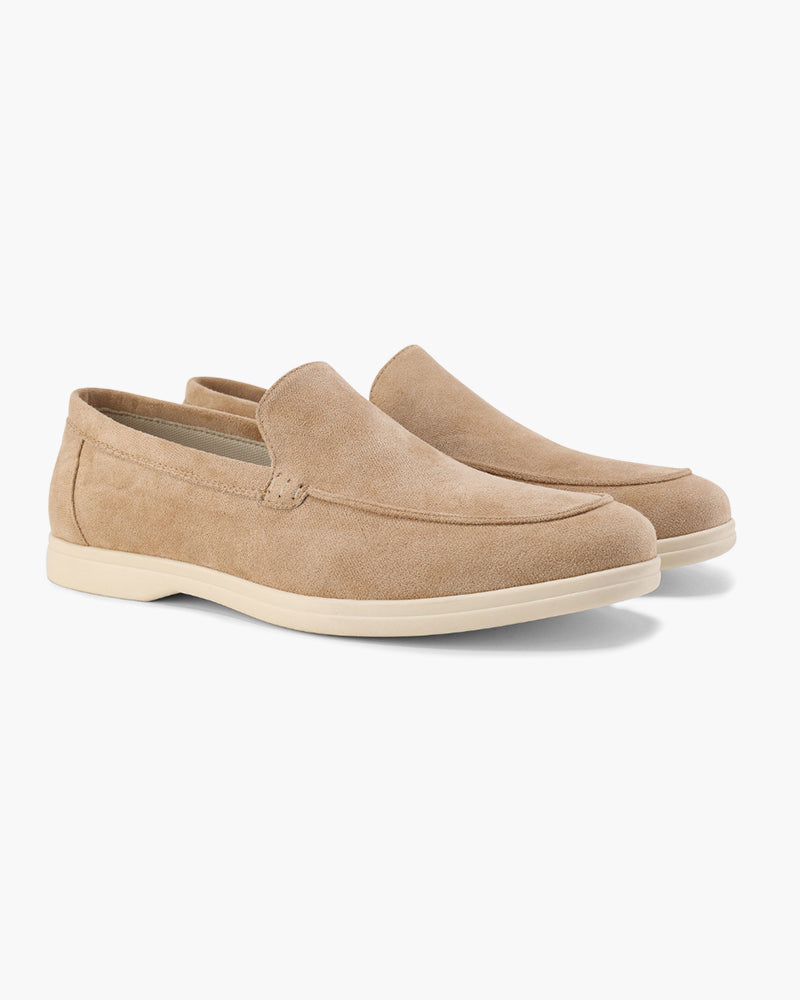 Pair of tan loafers on a white background