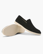 Black loafers with beige soles on a white background