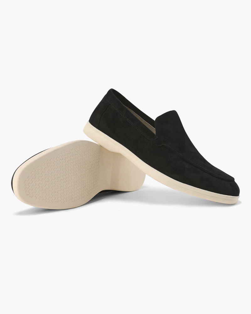 Black loafers with beige soles on a white background