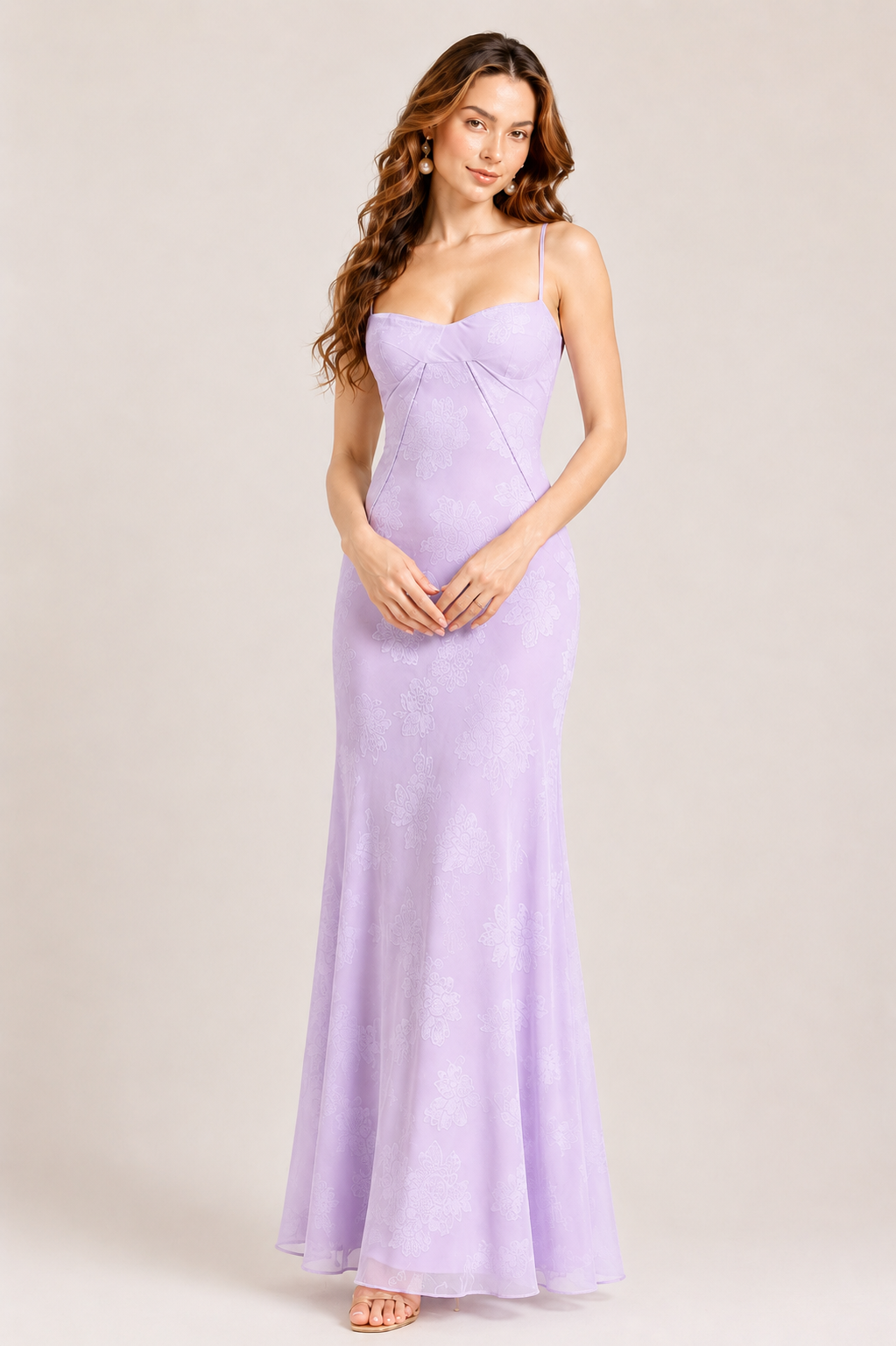 Woman wearing a lavender evening gown against a plain background