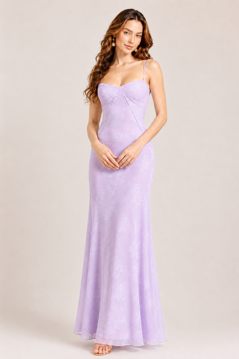 Woman wearing a lavender evening gown against a plain background