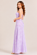 Woman wearing a strapless lavender gown against a plain background
