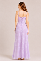 Woman wearing a lavender evening gown with a plain background