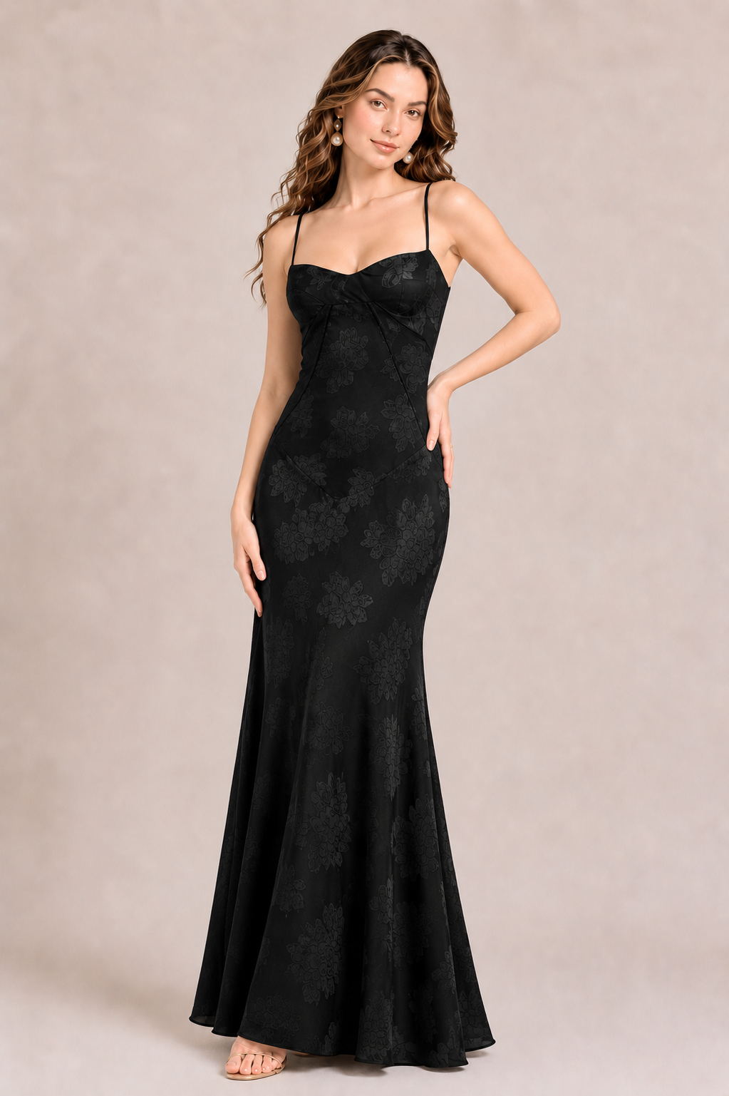 Woman wearing a black evening gown against a beige background