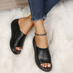 Black open-toe sandals worn on a white fluffy rug