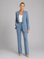 Woman wearing a light blue suit with a white top on a gray background