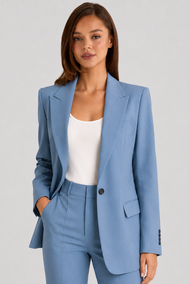 Woman wearing a light blue suit with a white top on a gray background