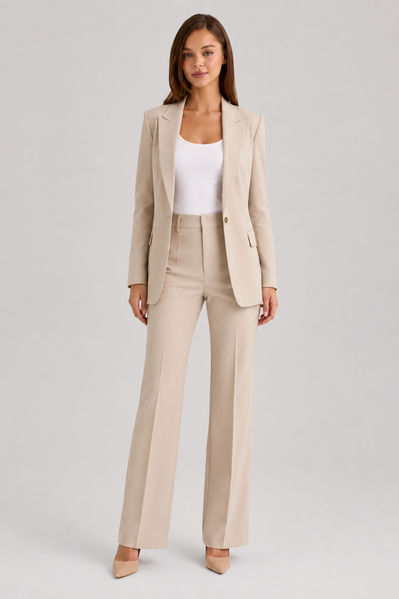 Woman wearing a beige suit with a white top on a light gray background