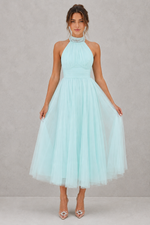 Woman wearing a light blue dress against a gray background