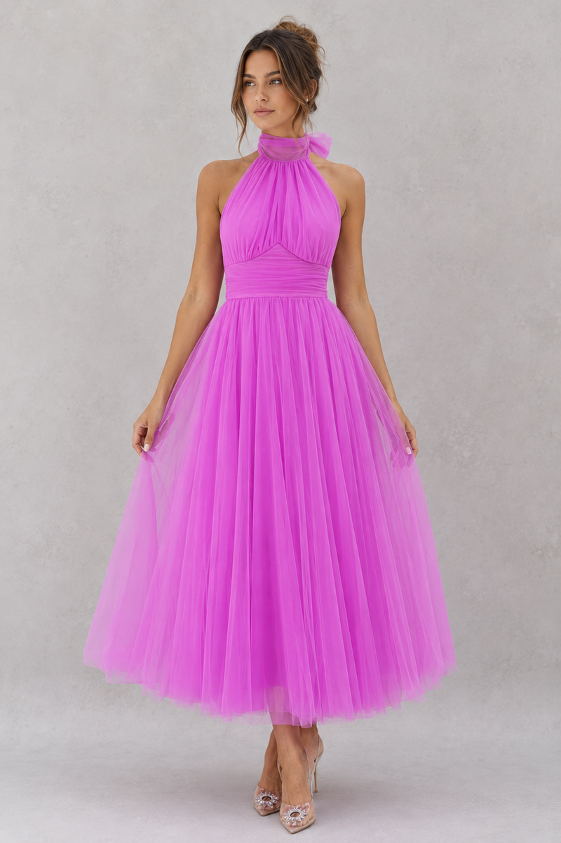 Woman wearing a pink dress against a gray background