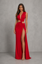 A woman modeling a bright red sleeveless maxi dress with a deep V-neckline, side cutouts, and a high thigh slit, standing against a textured gray studio backdrop.