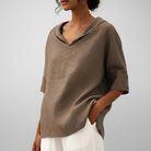 Person wearing a brown shirt with a plain background