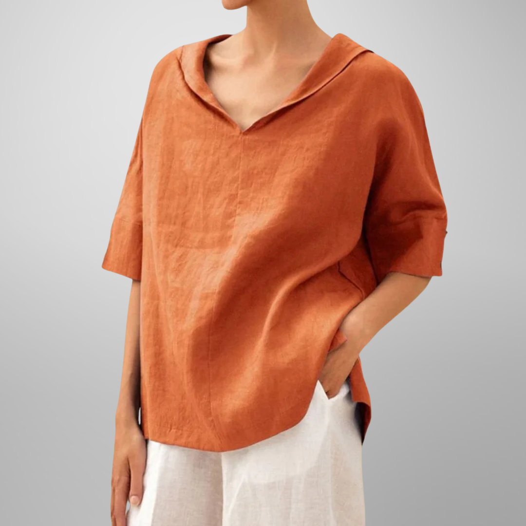 Person wearing an orange linen shirt with a plain background