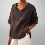 Person wearing a brown top with a plain background
