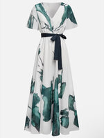 White dress with green leaf pattern and black belt on a white background