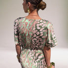 Woman wearing a patterned dress with a neutral background