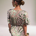 Woman wearing a patterned dress with a neutral background
