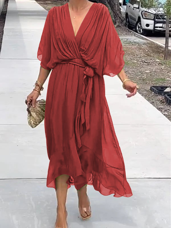 Woman wearing a red dress on a white pathway with a blurred background