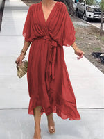 Woman wearing a red dress on a white pathway with a blurred background