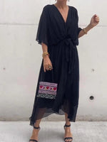 Woman wearing a black dress with embroidery on a white background