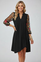 Black dress with floral sleeves against a white background