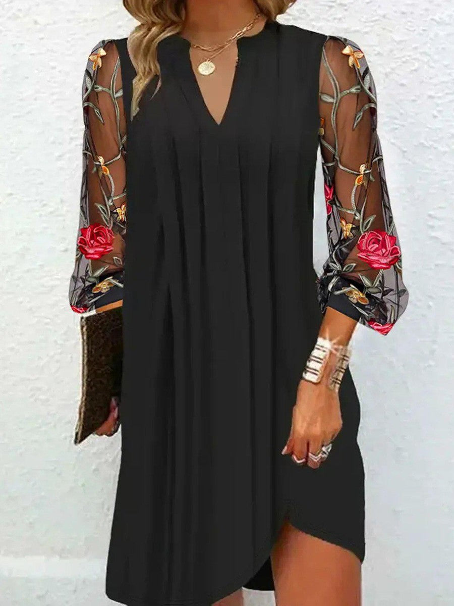 Black dress with floral sleeves against a white background