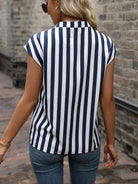 Woman wearing a navy and white striped shirt against a brick wall.