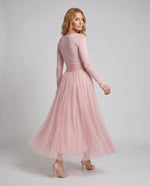 Woman wearing a pink dress on a plain background
