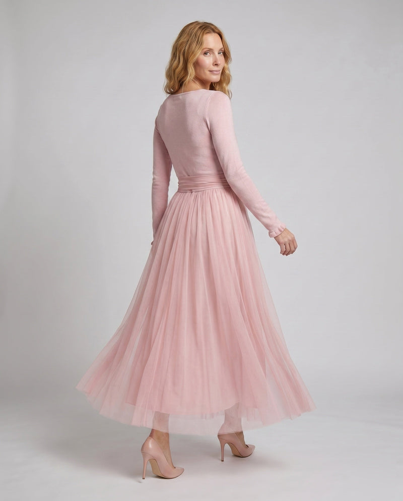 Woman wearing a pink dress on a plain background