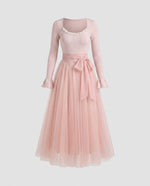Pink dress with long sleeves on a light gray background
